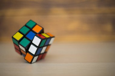 Renkli 3B kombinasyon Rubik küpü 3 'er 3' er tahta bir masada yatıyor.