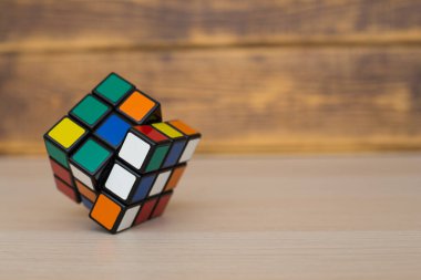 Renkli 3B kombinasyon Rubik küpü 3 'er 3' er tahta bir masada yatıyor.