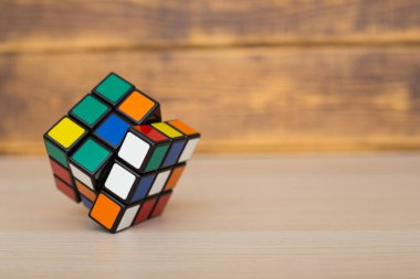 Renkli 3B kombinasyon Rubik küpü 3 'er 3' er tahta bir masada yatıyor.