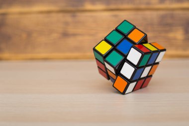 Renkli 3B kombinasyon Rubik küpü 3 'er 3' er tahta bir masada yatıyor.