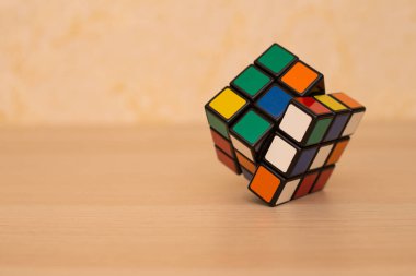 Renkli 3B kombinasyon Rubik küpü 3 'er 3' er tahta bir masada yatıyor.
