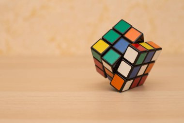 Renkli 3B kombinasyon Rubik küpü 3 'er 3' er tahta bir masada yatıyor.