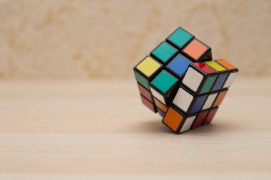 Renkli 3B kombinasyon Rubik küpü 3 'er 3' er tahta bir masada yatıyor.