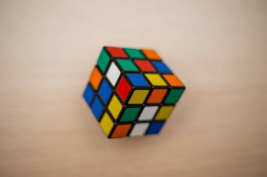 Renkli 3B kombinasyon Rubik küpü 3 'er 3' er tahta bir masada yatıyor.