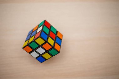 Renkli 3B kombinasyon Rubik küpü 3 'er 3' er tahta bir masada yatıyor.