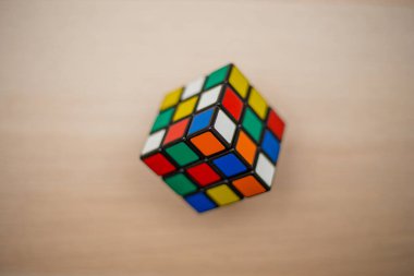 Renkli 3B kombinasyon Rubik küpü 3 'er 3' er tahta bir masada yatıyor.