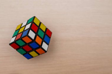 Renkli 3B kombinasyon Rubik küpü 3 'er 3' er tahta bir masada yatıyor.