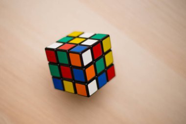 Renkli 3B kombinasyon Rubik küpü 3 'er 3' er tahta bir masada yatıyor.