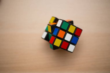 Renkli 3B kombinasyon Rubik küpü 3 'er 3' er tahta bir masada yatıyor.
