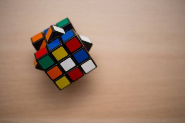 Renkli 3B kombinasyon Rubik küpü 3 'er 3' er tahta bir masada yatıyor.