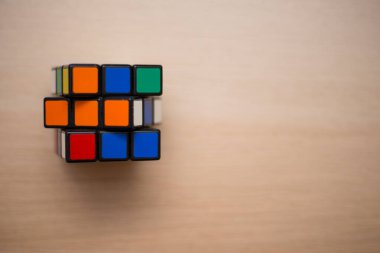 Renkli 3B kombinasyon Rubik küpü 3 'er 3' er tahta bir masada yatıyor.