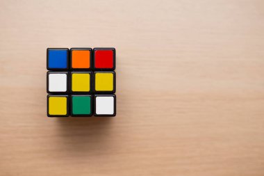 Renkli 3B kombinasyon Rubik küpü 3 'er 3' er tahta bir masada yatıyor.