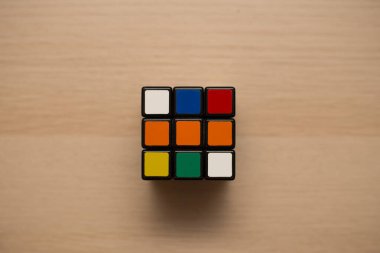 Renkli 3B kombinasyon Rubik küpü 3 'er 3' er tahta bir masada yatıyor.