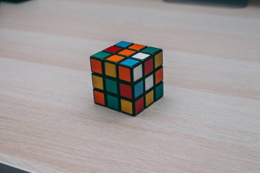 Renkli 3B kombinasyon Rubik küpü 3 'er 3' er tahta bir masada yatıyor.