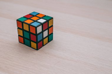 Renkli 3B kombinasyon Rubik küpü 3 'er 3' er tahta bir masada yatıyor.
