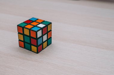 Renkli 3B kombinasyon Rubik küpü 3 'er 3' er tahta bir masada yatıyor.
