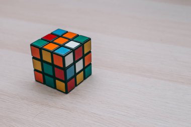 Renkli 3B kombinasyon Rubik küpü 3 'er 3' er tahta bir masada yatıyor.