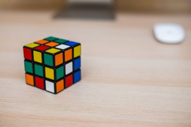 Renkli 3B kombinasyon Rubik küpü 3 'er 3' er tahta bir masada yatıyor.