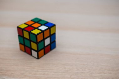 Renkli 3B kombinasyon Rubik küpü 3 'er 3' er tahta bir masada yatıyor.