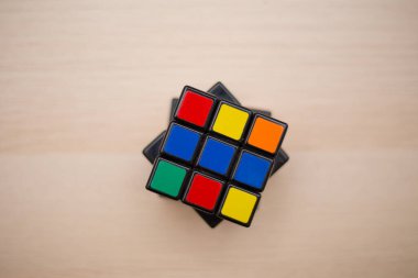 Renkli 3B kombinasyon Rubik küpü 3 'er 3' er tahta bir masada yatıyor.