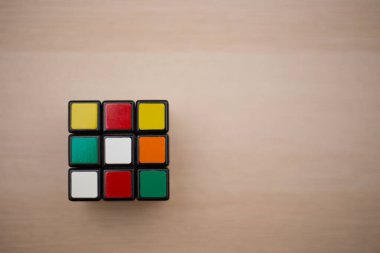 Renkli 3B kombinasyon Rubik küpü 3 'er 3' er tahta bir masada yatıyor.