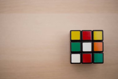 Renkli 3B kombinasyon Rubik küpü 3 'er 3' er tahta bir masada yatıyor.
