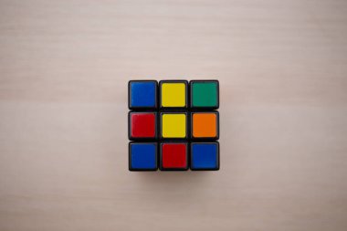 Renkli 3B kombinasyon Rubik küpü 3 'er 3' er tahta bir masada yatıyor.