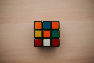 Renkli 3B kombinasyon Rubik küpü 3 'er 3' er tahta bir masada yatıyor.
