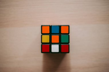 Renkli 3B kombinasyon Rubik küpü 3 'er 3' er tahta bir masada yatıyor.