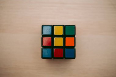 Renkli 3B kombinasyon Rubik küpü 3 'er 3' er tahta bir masada yatıyor.