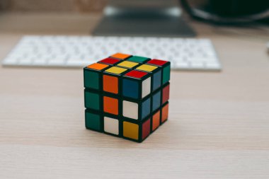 Renkli 3B kombinasyon Rubik küpü 3 'er 3' er tahta bir masada yatıyor.