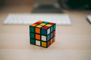 Renkli 3B kombinasyon Rubik küpü 3 'er 3' er tahta bir masada yatıyor.