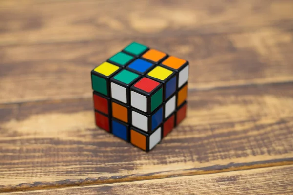 Renkli 3B kombinasyon Rubik küpü 3 'er 3' er tahta bir masada yatıyor.