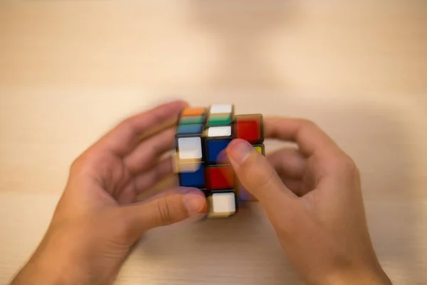 Elleri Renkli Bir Yapboz Rubik Küpü Tahta Bir Masada Yatıyor — Stok fotoğraf
