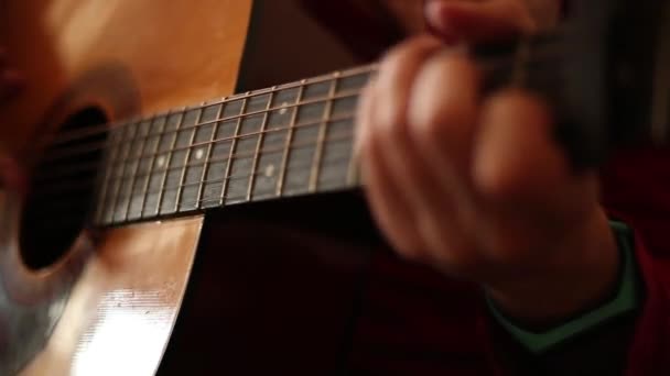 Ένας Άντρας Κόκκινο Πουλόβερ Παίζει Μια Ακουστική Κιθάρα Εσωτερικούς Χώρους — Αρχείο Βίντεο