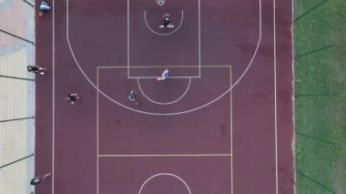 Sokakta basketbol oynayan genç bir adamın hava manzarası.