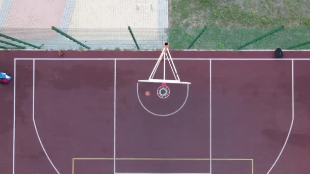 Luftaufnahme eines jungen Mannes beim Basketballspielen auf der Straße — Stockvideo