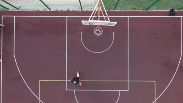 Luftaufnahme eines jungen Mannes beim Basketballspielen auf der Straße — Stockvideo