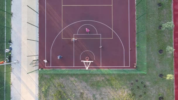 Вид с воздуха на молодого парня, играющего в баскетбол на улице — стоковое видео