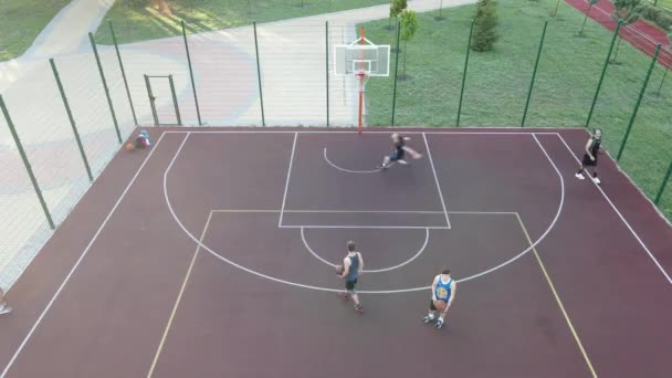 Letecký pohled na mladíka, který hraje basketbal na ulici — Stock video