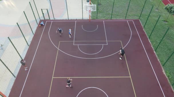 Letecký pohled na mladíka, který hraje basketbal na ulici — Stock video