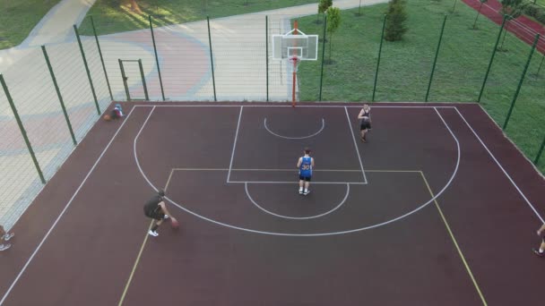 Letecký pohled na mladíka, který hraje basketbal na ulici — Stock video