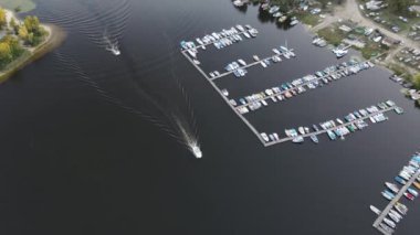 Deniz kıyısındaki bir körfezde demirlemiş yatların insansız hava aracı görüntüsü.