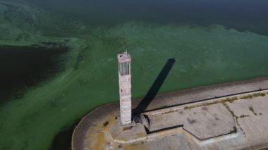 Yeşil çamurlu suların yanındaki eski deniz fenerinin havadan görünüşü