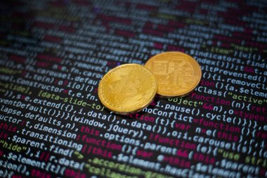 Program kodunun arka planında iki altın bitcoin para