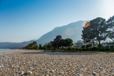 Antalya Kemer 'in arka planında dağlar olan deniz kıyısında bir sahil.