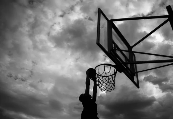 Silhueta Homem Que Joga Uma Bola Aro Basquete Rua Contra — Fotografia de Stock