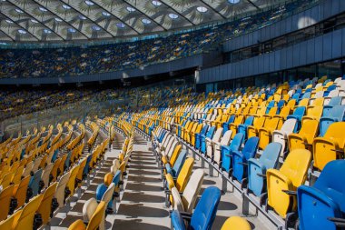 Sarı ve mavi bankları olan olimpiyat stadyumunda boş koltuklar.