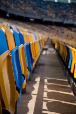 Sarı ve mavi bankları olan olimpiyat stadyumunda boş koltuklar.