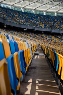 Sarı ve mavi bankları olan olimpiyat stadyumunda boş koltuklar.